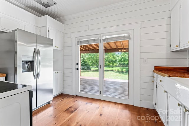 233 Sellars Rd, Kings Mountain, NC 28086 - kitchen with stainless steel fridge, light wood-style floors, wooden walls, white cabinetry, and crown molding