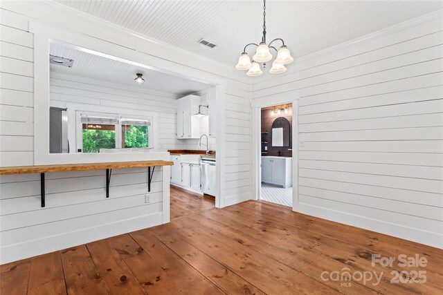 233 Sellars Rd, Kings Mountain, NC 28086 - kitchen with white cabinets, a breakfast bar, a chandelier, hardwood / wood-style floors, and pendant lighting