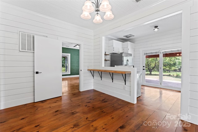 233 Sellars Rd, Kings Mountain, NC 28086 - kitchen with stainless steel fridge with ice dispenser, wood-type flooring, a chandelier, a peninsula, and wood walls