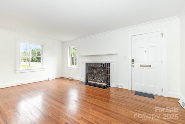1400 Matheson Ave, Charlotte, NC 28205 - unfurnished living room featuring wood finished floors, crown molding, a tiled fireplace, and baseboards