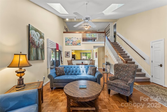 903 Independence Trl, Morganton, NC 28655 - living room with a skylight, ceiling fan, stairway, a towering ceiling, and baseboards