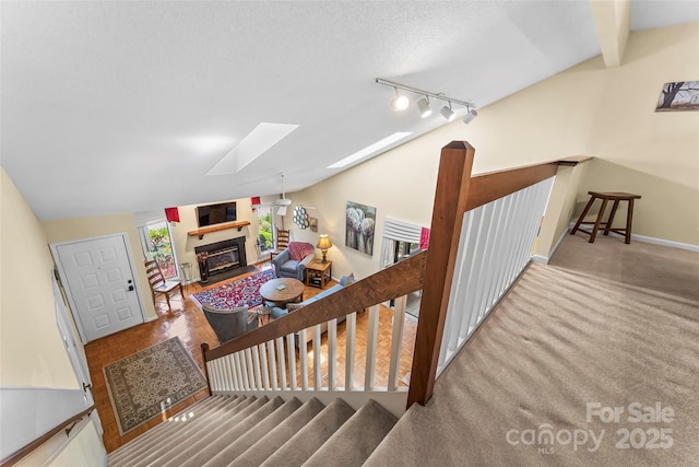 903 Independence Trl, Morganton, NC 28655 - staircase with a skylight, a glass covered fireplace, lofted ceiling, rail lighting, and baseboards