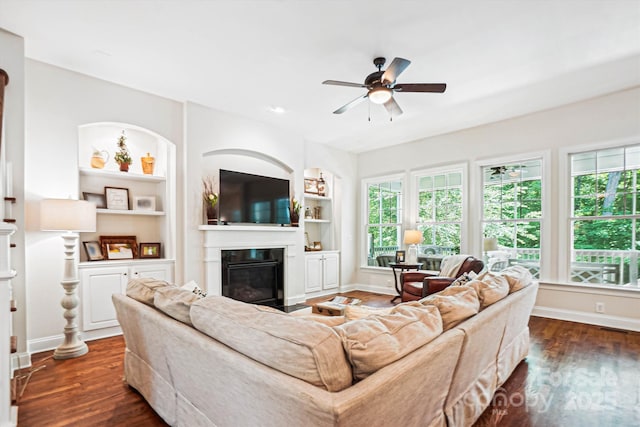 5424 Morris Hunt Dr, Fort Mill, SC 29708 - living area featuring a glass covered fireplace, ceiling fan, dark wood-type flooring, and baseboards