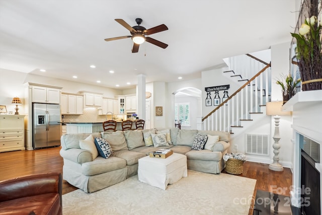 5424 Morris Hunt Dr, Fort Mill, SC 29708 - living area featuring a ceiling fan, wood finished floors, arched walkways, stairway, and a fireplace