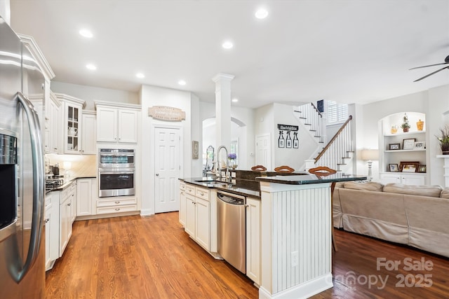 5424 Morris Hunt Dr, Fort Mill, SC 29708 - kitchen with appliances with stainless steel finishes, a sink, open floor plan, light wood-type flooring, and ceiling fan