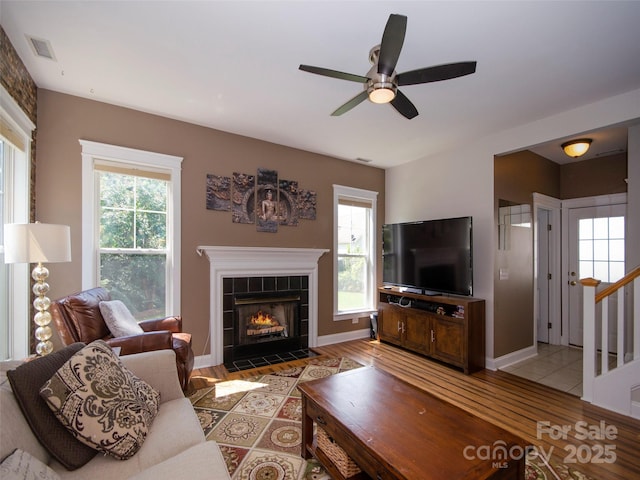 1410 Kenton Ln, Asheville, NC 28803 - living area featuring ceiling fan, wood finished floors, a tile fireplace, stairs, and baseboards