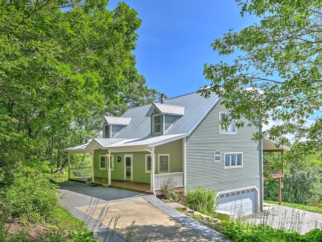 58 Randall Dr, Fairview, NC 28730 - view of front of house featuring driveway, a porch, metal roof, a standing seam roof, and an attached garage