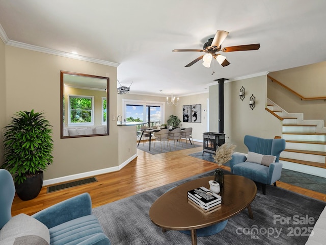 58 Randall Dr, Fairview, NC 28730 - living area featuring baseboards, crown molding, a wood stove, stairs, and a ceiling fan