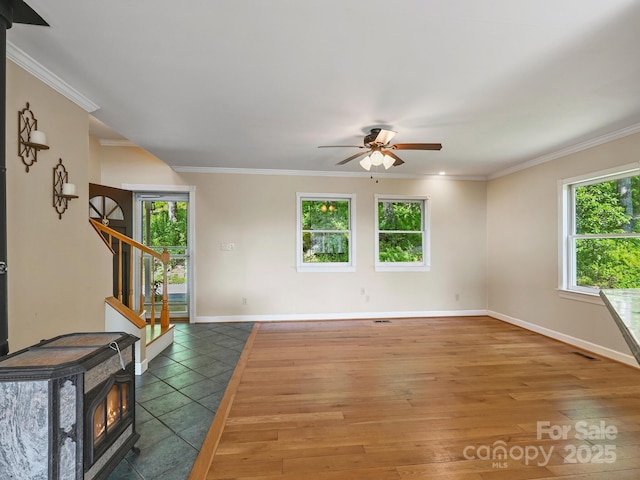 58 Randall Dr, Fairview, NC 28730 - unfurnished room featuring plenty of natural light, stairway, ceiling fan, a wood stove, and ornamental molding
