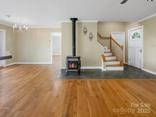 58 Randall Dr, Fairview, NC 28730 - unfurnished living room featuring hardwood / wood-style floors, crown molding, a wood stove, stairs, and baseboards