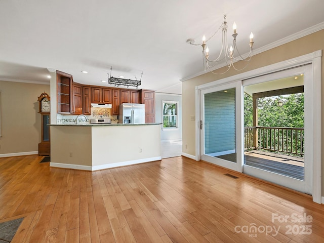 58 Randall Dr, Fairview, NC 28730 - kitchen with stainless steel fridge, a chandelier, open shelves, ornamental molding, and under cabinet range hood
