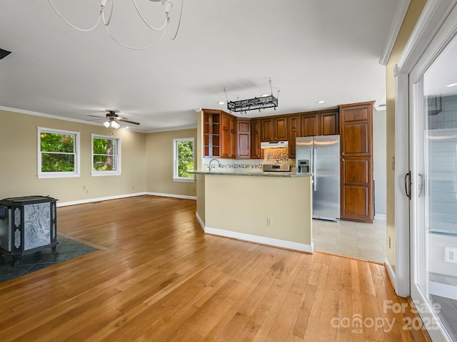 58 Randall Dr, Fairview, NC 28730 - kitchen featuring appliances with stainless steel finishes, under cabinet range hood, a wood stove, light wood-style flooring, and open shelves