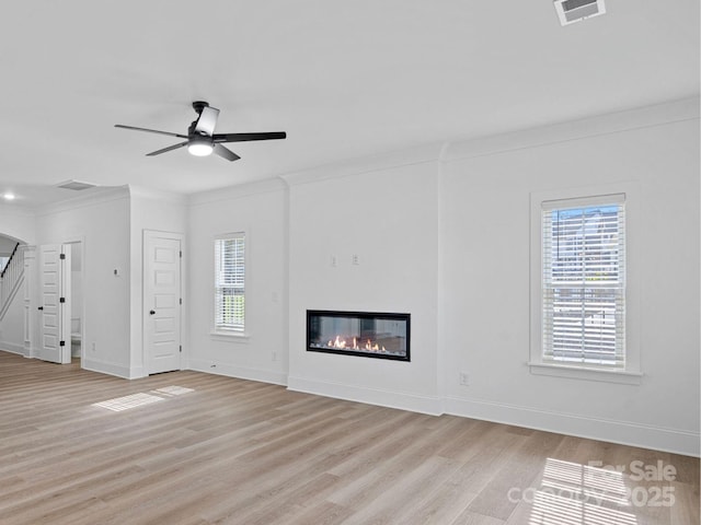 6712 W Sugar Creek Rd, Charlotte, NC 28269 - unfurnished living room with light wood-type flooring, baseboards, a glass covered fireplace, a ceiling fan, and crown molding