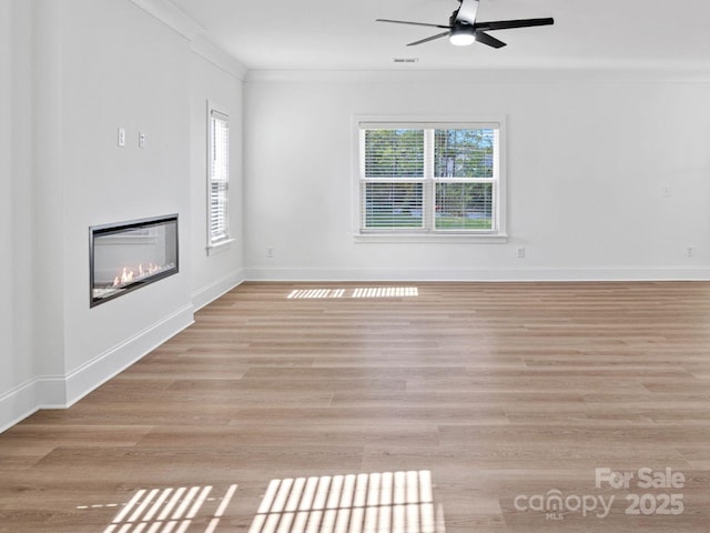6712 W Sugar Creek Rd, Charlotte, NC 28269 - unfurnished living room with crown molding, a ceiling fan, a glass covered fireplace, light wood-type flooring, and baseboards
