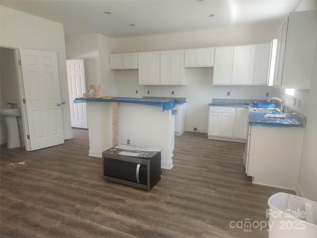 2300 Grayson Pkwy, Monroe, NC 28110 - kitchen featuring white cabinets, dark wood-type flooring, a center island, and a sink