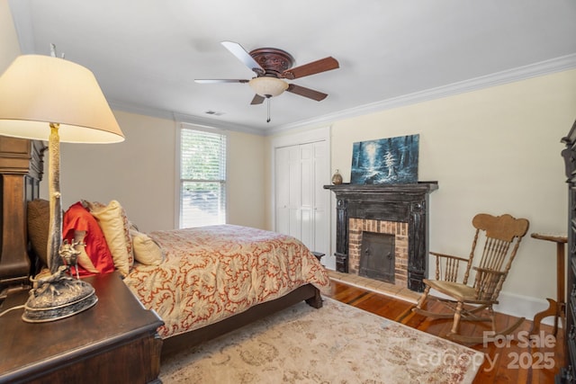 420 S Cedar St, Lincolnton, NC 28092 - bedroom with wood finished floors, ornamental molding, a fireplace, a closet, and a ceiling fan