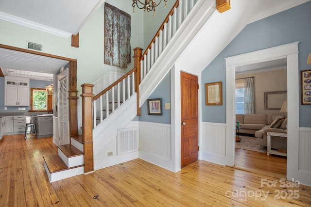 420 S Cedar St, Lincolnton, NC 28092 - staircase with hardwood / wood-style flooring, a wainscoted wall, ornamental molding, a chandelier, and vaulted ceiling