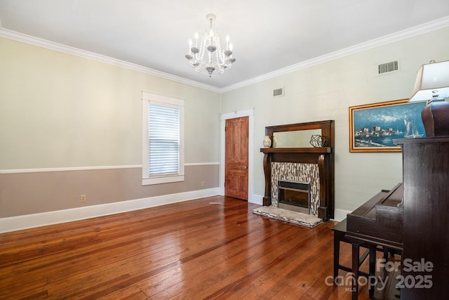 420 S Cedar St, Lincolnton, NC 28092 - living room with a chandelier, wood-type flooring, ornamental molding, a tiled fireplace, and baseboards