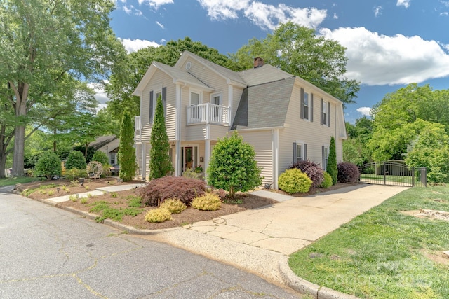 420 S Cedar St, Lincolnton, NC 28092 - view of front facade featuring a gate, a shingled roof, a balcony, a chimney, and concrete driveway