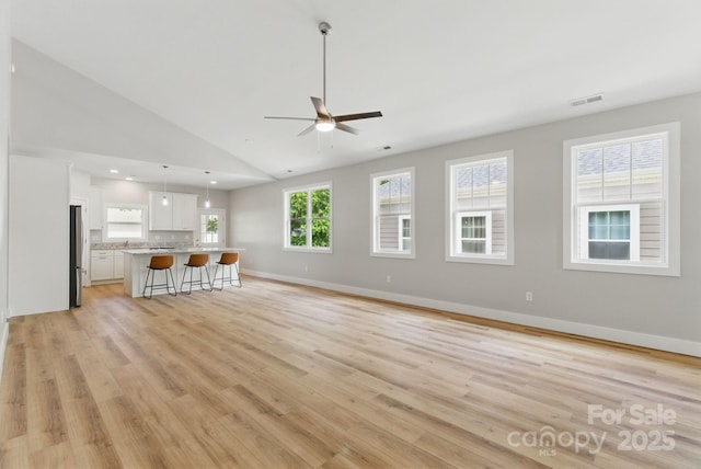 192 Plato Pl, Etowah, NC 28729 - unfurnished living room featuring a ceiling fan, light wood-type flooring, baseboards, and high vaulted ceiling