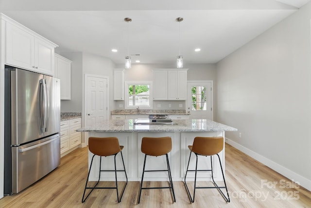 192 Plato Pl, Etowah, NC 28729 - kitchen featuring freestanding refrigerator, white cabinets, a breakfast bar, a center island, and recessed lighting