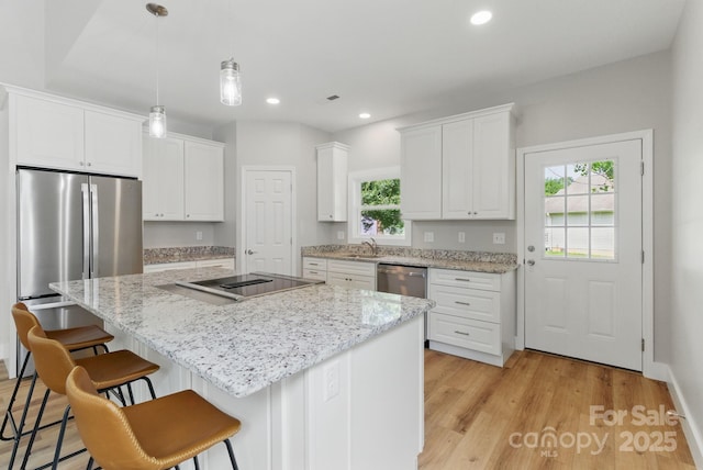 192 Plato Pl, Etowah, NC 28729 - kitchen featuring appliances with stainless steel finishes, a kitchen island, white cabinetry, a kitchen bar, and recessed lighting