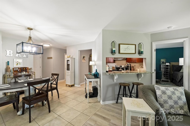 2533 Stockbridge Dr, Charlotte, NC 28210 - dining area with light tile patterned flooring, a chandelier, and baseboards