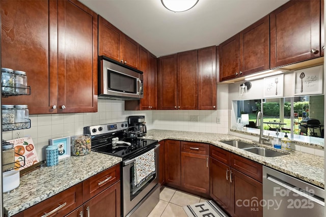 2533 Stockbridge Dr, Charlotte, NC 28210 - kitchen featuring appliances with stainless steel finishes, a sink, light tile patterned flooring, backsplash, and light stone counters