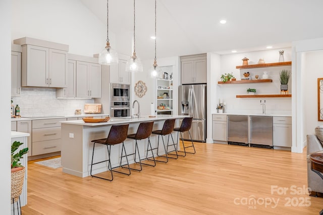 15 Ledgestone Dr, Fairview, NC 28730 - kitchen featuring appliances with stainless steel finishes, open shelves, gray cabinetry, light countertops, and backsplash