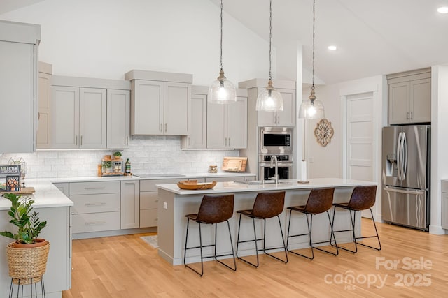 15 Ledgestone Dr, Fairview, NC 28730 - kitchen featuring stainless steel appliances, gray cabinetry, light countertops, a kitchen breakfast bar, and high vaulted ceiling