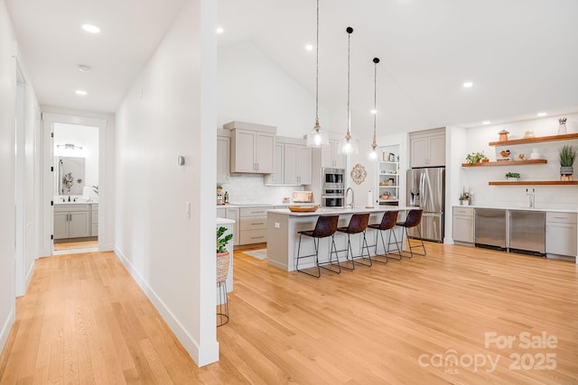 15 Ledgestone Dr, Fairview, NC 28730 - kitchen featuring stainless steel appliances, gray cabinets, a breakfast bar, light wood-style flooring, and high vaulted ceiling