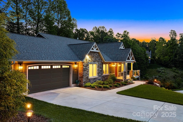 15 Ledgestone Dr, Fairview, NC 28730 - view of front of house with stone siding, driveway, a garage, a shingled roof, and a porch