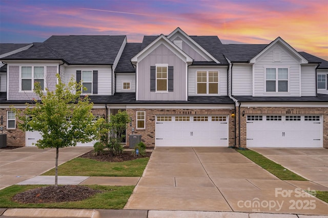 9009 Odell Corners Blvd NW, Concord, NC 28027 - view of property featuring board and batten siding, an attached garage, concrete driveway, and central AC