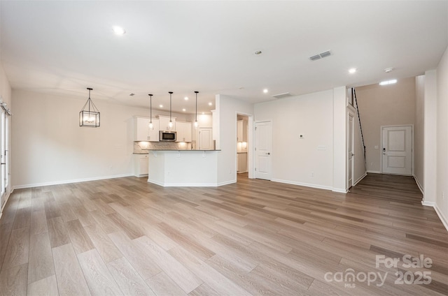 9009 Odell Corners Blvd NW, Concord, NC 28027 - unfurnished living room with recessed lighting, light wood-style floors, baseboards, and a chandelier