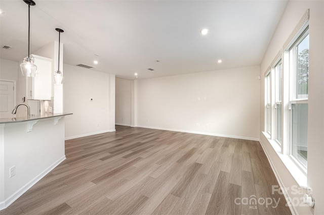 9009 Odell Corners Blvd NW, Concord, NC 28027 - unfurnished living room featuring light wood-style floors, a sink, baseboards, and recessed lighting