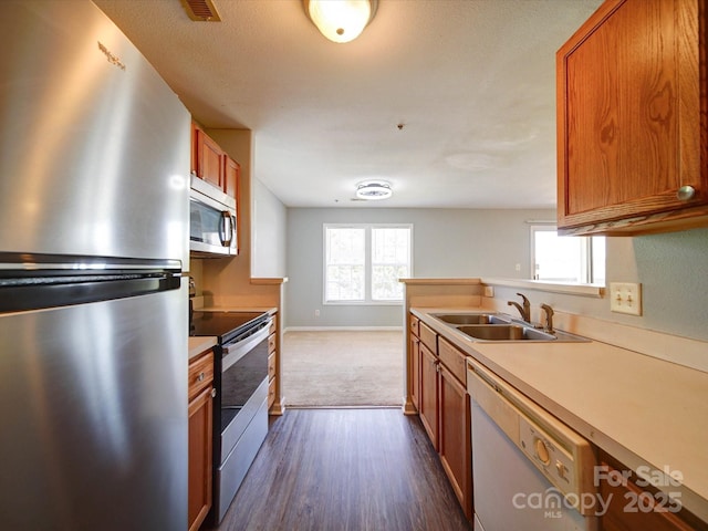 1023 Triece Ln, Charlotte, NC 28215 - kitchen featuring appliances with stainless steel finishes, a sink, plenty of natural light, and brown cabinets