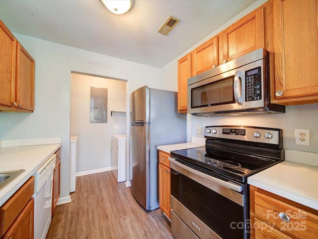 1023 Triece Ln, Charlotte, NC 28215 - kitchen featuring appliances with stainless steel finishes, light wood-type flooring, electric panel, light countertops, and brown cabinets