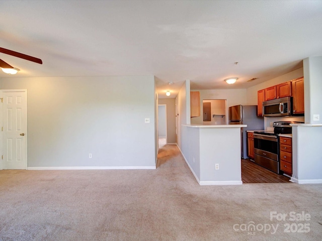 1023 Triece Ln, Charlotte, NC 28215 - kitchen with stainless steel appliances, light carpet, ceiling fan, baseboards, and light countertops