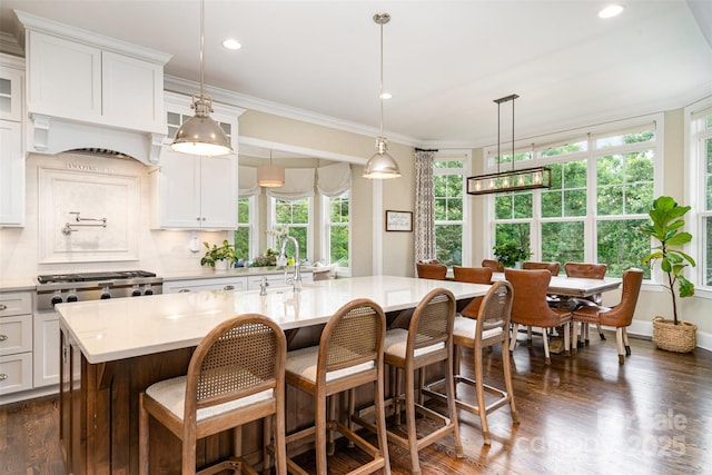 6873 Pine Moss Ln, Clover, SC 29710 - kitchen featuring light countertops, ornamental molding, white cabinetry, glass insert cabinets, and an island with sink