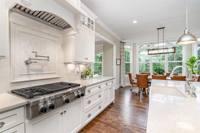 6873 Pine Moss Ln, Clover, SC 29710 - kitchen with stainless steel gas stovetop, custom exhaust hood, decorative backsplash, dark wood-style floors, and white cabinetry