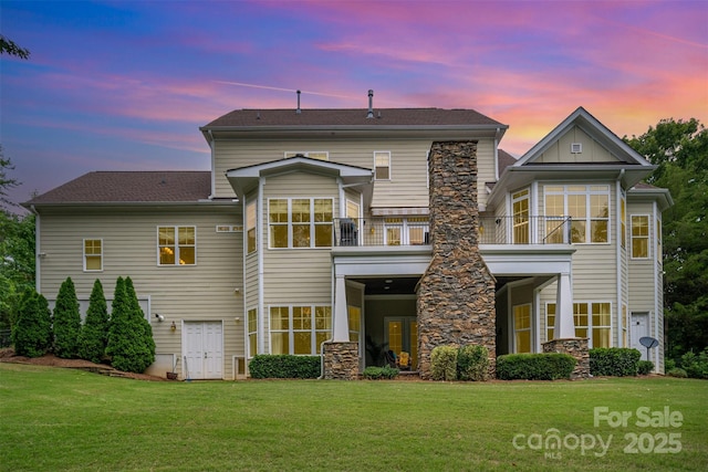 6873 Pine Moss Ln, Clover, SC 29710 - back of property at dusk featuring a lawn, stone siding, a sunroom, and a balcony