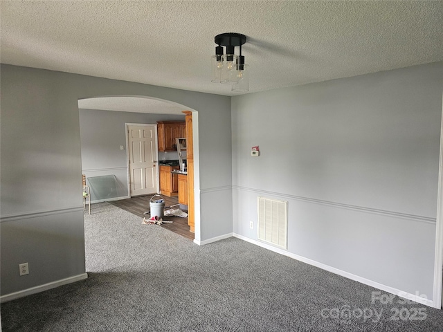 905 Klondale St, China Grove, NC 28023 - unfurnished room with arched walkways, dark carpet, a textured ceiling, and baseboards
