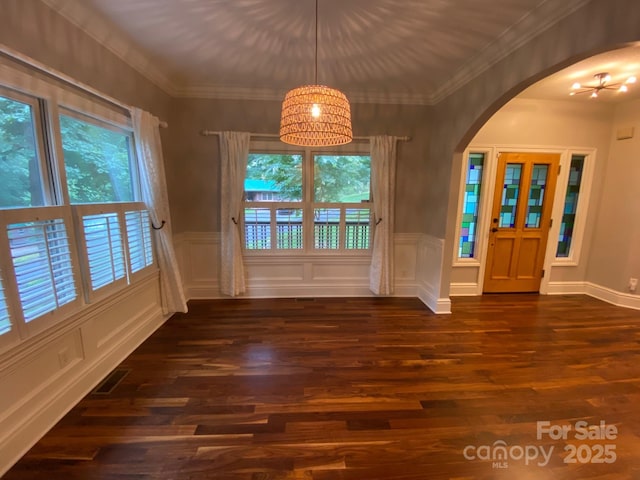 6 Woodland Rd W, Asheville, NC 28806 - unfurnished dining area featuring healthy amount of natural light, arched walkways, dark wood-style flooring, wainscoting, and a decorative wall