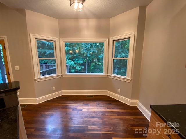 6 Woodland Rd W, Asheville, NC 28806 - unfurnished dining area with dark wood-type flooring and baseboards