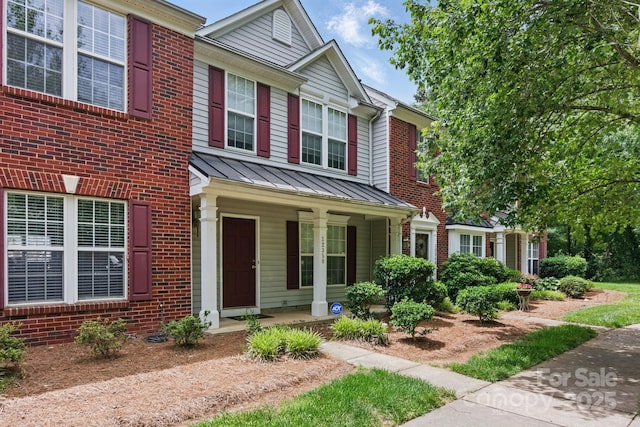 12350 Swan Wings Pl, Huntersville, NC 28078 - view of front facade with a porch, a standing seam roof, brick siding, and metal roof