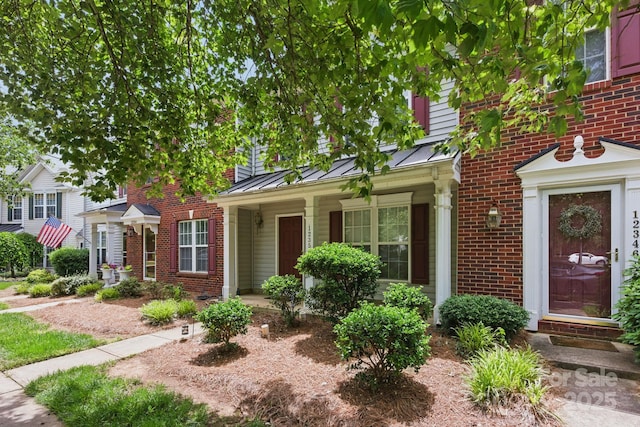 12350 Swan Wings Pl, Huntersville, NC 28078 - view of front of property featuring a standing seam roof, brick siding, metal roof, and a porch