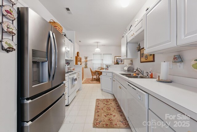 12350 Swan Wings Pl, Huntersville, NC 28078 - kitchen featuring white appliances, a sink, light countertops, white cabinets, and hanging light fixtures