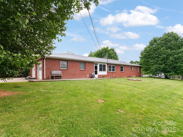 391 Ellen Ave, Canton, NC 28716 - back of property featuring brick siding, an attached garage, a lawn, and metal roof
