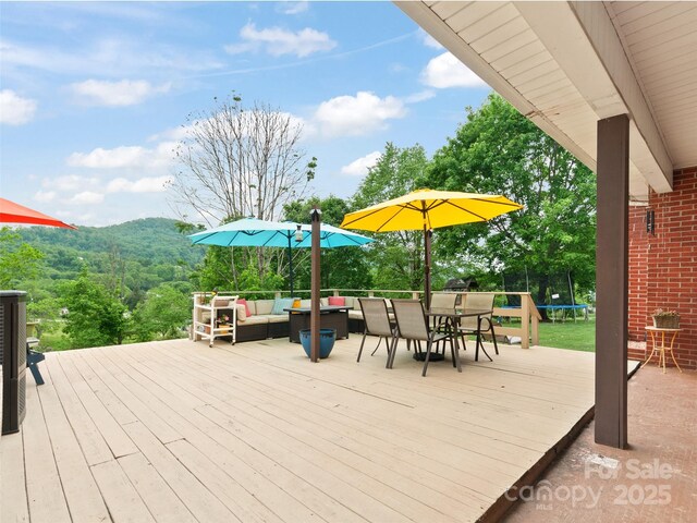391 Ellen Ave, Canton, NC 28716 - wooden deck featuring a trampoline, an outdoor hangout area, outdoor dining area, and a mountain view