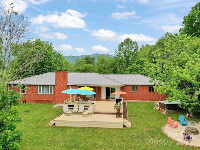 391 Ellen Ave, Canton, NC 28716 - rear view of house featuring a jacuzzi, an outdoor fire pit, a deck with mountain view, and a lawn